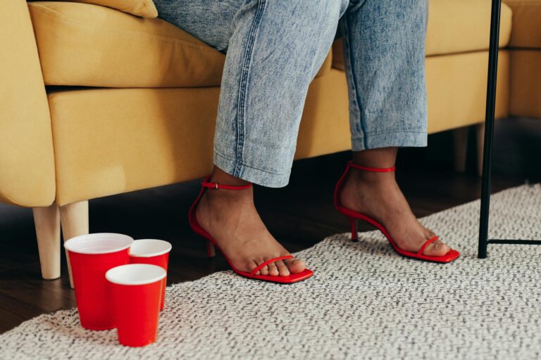 Stylish red stilettos indoors with paper cups, casual and fashionable vibe.